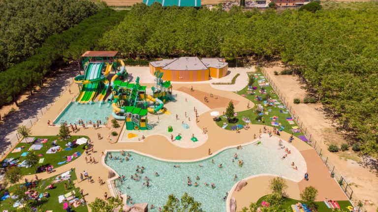 Aerial view of pools, green water slides and surrounding lawns