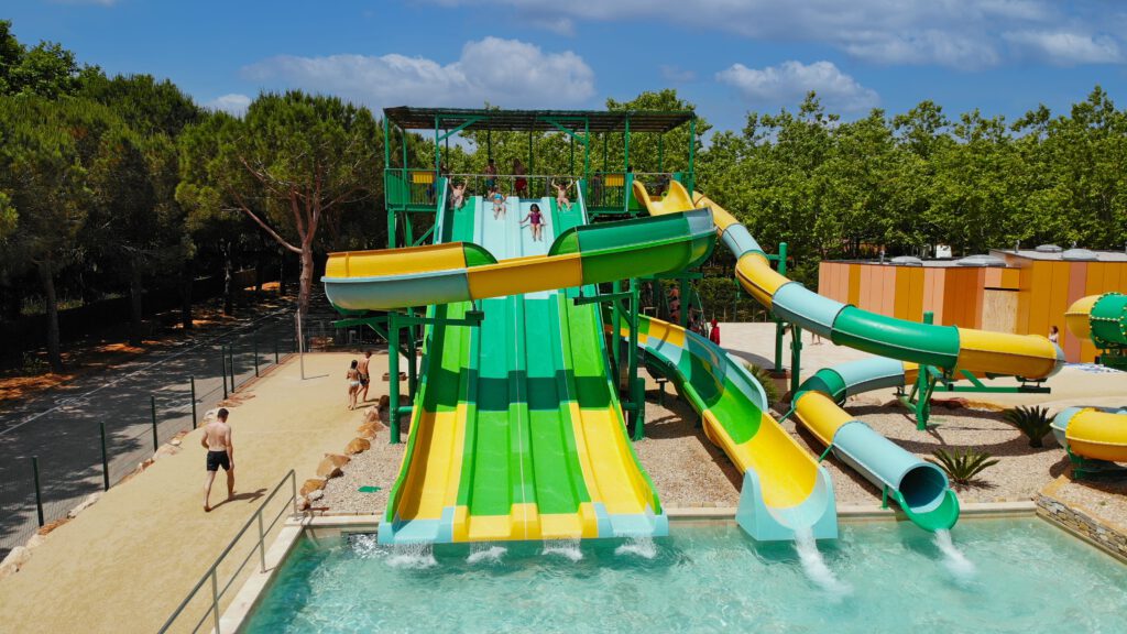 Green and yellow water slides leading into a pool